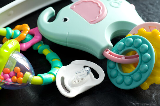 Macro Image of Baby Pacifier with Colorful Toys on Black Background