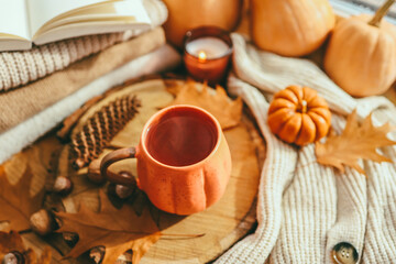 Autumn cozy decor, cup of tea, candles, pumpkins