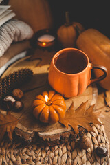 A cup of tea in the shape of a pumpkin and autumn decor on the windowsill, aesthetic photo.