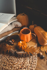 Autumn home interior, thanksgiving decoration, cup of tea and candle pumpkin