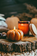 Burning candle in the shape of a pumpkin, autumn aesthetic mood