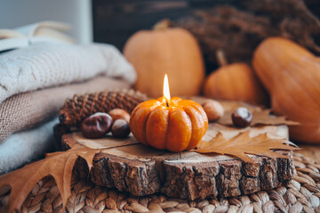Burning candle in the shape of a pumpkin, autumn aesthetic mood