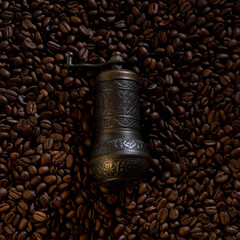 Old coffee grinder with coffee beans in the background