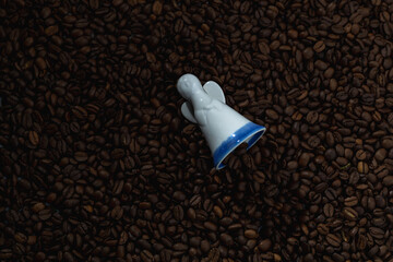 Figurine of an angel on a background of coffee beans