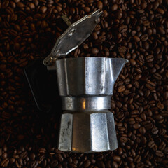 Italian geyser coffee maker on a background of coffee beans