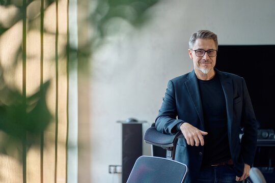 Portrait of confident businessman in business casual. Happy middle aged, mid adult, mature age man smiling. Entrepreneur in modern office.