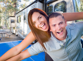 Fototapeta na wymiar Young Adult Military Couple In Front of Their Beautiful RV At The Campground.