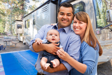 Happy Multiethnic Caucasian and Hispanic Couple with Baby In Front of Their Beautiful RV At The...