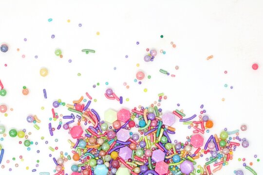 Bunte Zuckerstreusel auf wei&szlig;en Hintergrund.