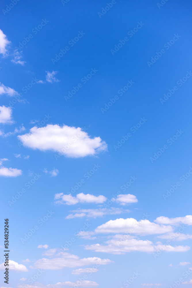 Wall mural blue sky with white clouds - vertical background