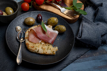 Stück Focaccia Brot mit Schinken, Oliven und Kräutern