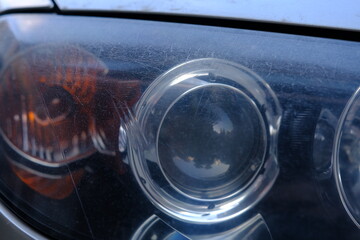 Close-up head light of car with scratches and need to polish in service. Polish car concept. Car lights service