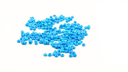 Group of scattered blue beads isolated on white background.