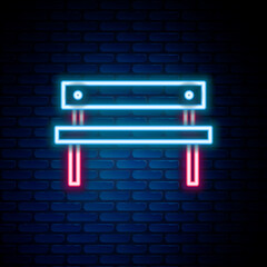 Glowing neon line Bench icon isolated on brick wall background. Colorful outline concept. Vector