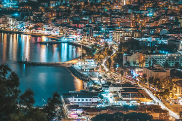 Seaside city kusadasi at night with lights of buildings and reflection on sea