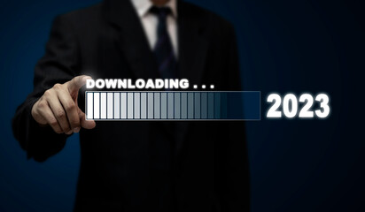 A businessman taps a virtual download bar with a loading progress meter on New Year's Eve, turning...