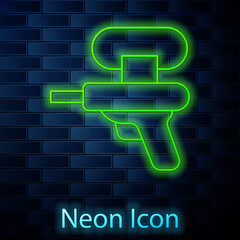 Glowing neon line Water gun icon isolated on brick wall background. Vector