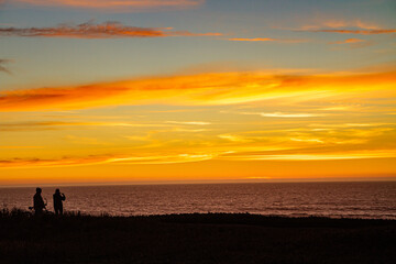 Fototapeta premium Silhouette of a couple enjoying the sunset over teh sea 