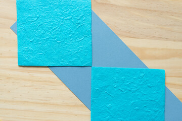 paper background with blue paper squares and wood