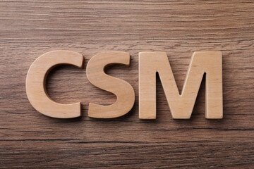 Abbreviation CSM (Customer Service Management) made of letters on wooden background, flat lay