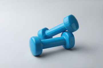 Two new blue vinyl dumbbells on light background