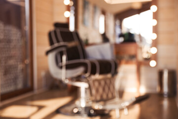 Fototapeta na wymiar Blurred view of stylish barbershop interior with hairdresser workplace