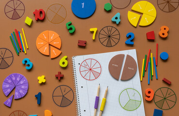 Set of supplies for mathematics and for school. Fractions, rulers, pencils, notepad on brown...