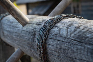Old wooden winch of well with chain. lifting mechanism of water from the draw well