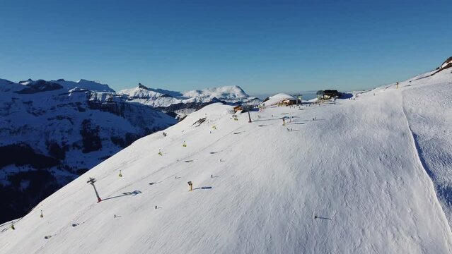 Grindelwald, Switzerland: Aerial drone footage of ski chair lifts in the Jungfrau region ski resort at the Kleine Scheidegg in the Berner Oberland alps near Interlaken on a sunny winter day