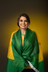 Brazilian fan. Brazilian woman fan celebrating in soccer or soccer match on yellow background. Brazil colors.