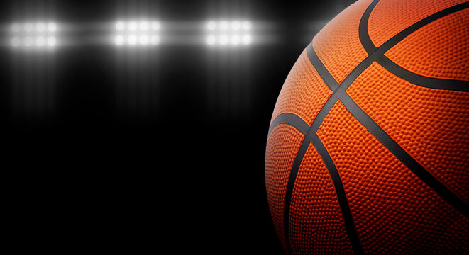 Basketball on a black background under stadium lights