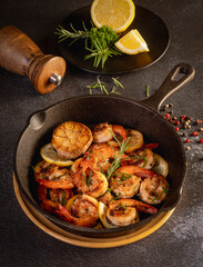 Spicy garlic chilli Prawns Shrimps on frying pan with lemon and cilantro