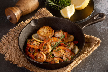 Spicy garlic chilli Prawns Shrimps on frying pan with lemon and cilantro