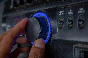 Person hand is adjusting speaker volume. Sound music black color speaker closup.