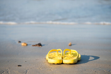 Fototapeta na wymiar Yelllow flipflop shoes on beach at Krabi