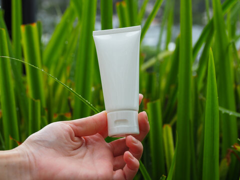 white cream tube on a natural green background skin care natural extracts