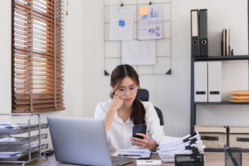 Business concept, Businesswoman reading business data on smartphone while sitting in modern office