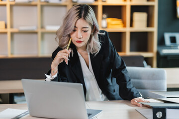 Asian beautiful businesswoman seriously working thinking idea for work on computer and think...