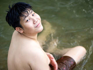 Asian teenager boy playing in the river.