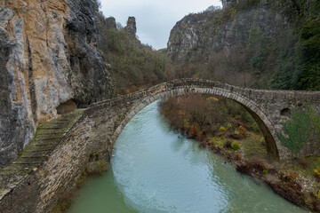 Fototapeta na wymiar Kokori's old arch stone bridge (Noutsos) during fall season situated on the river of Voidomatis in Zagori, Epirus Greece.