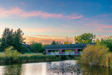 covered bridge on the lake at sunset