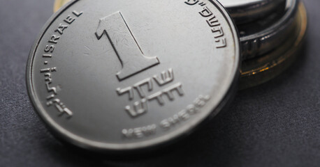 Translation: 1 new shekel Israel. Israeli money. 1 one shekel coin and a stack of other coins. National currency. Close-up. Horizontal stories for news about economy or finance. Macro - obrazy, fototapety, plakaty