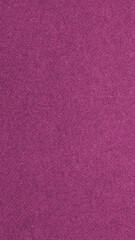 Dark pink colored paper texture. Tinted vertical background. Textured mobile phone wallpaper. Large patterned surface. Fibers and irregularities are visible. Top-down