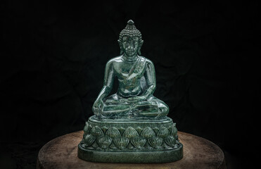 Figurine of Emerald lord buddha gautama or Siddhattha gotama buddha sculpture statue with dark background. Space for text, Selective focus.