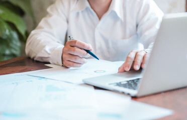 Hand businessman signing contract. Asia businessman check the correctness of work at the office with a beautiful pen. Hands working with documents at desk and signing contract.Deal concept.