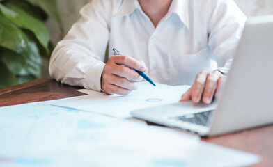 Hand businessman signing contract. Asia businessman check the correctness of work at the office with a beautiful pen. Hands working with documents at desk and signing contract.Deal concept.
