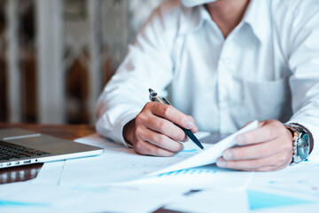 Hand businessman signing contract. Asia businessman check the correctness of work at the office with a beautiful pen. Hands working with documents at desk and signing contract.Deal concept.