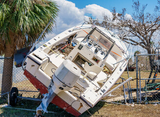 Boat tossed onto a fence after Hurricane Ian Fort Myers FL