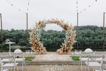  The wedding arch is made of fresh flowers and dried reeds. Away wedding ceremony.