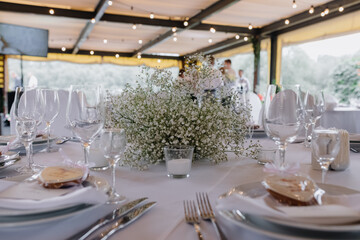  Table service for a party or wedding. luxury elegant dinner table setting in restaurant. glasses, dishes and flowers